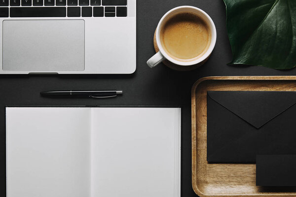 Шаблон рабочего места офиса с ноутбуком на черном фоне
