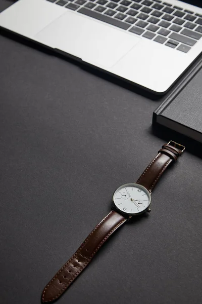 Braune Uhr Mit Offenem Laptop Auf Schwarzem Hintergrund — kostenloses Stockfoto