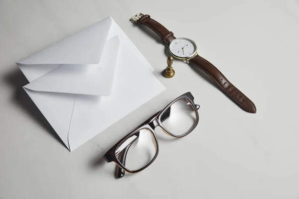 Witte Enveloppen Met Bril Horloge Witte Marmeren Achtergrond — Gratis stockfoto