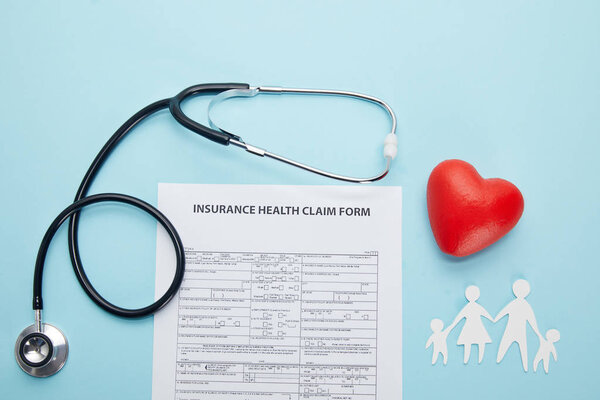 верхний вид страховой медицинской формы претензии, бумаги вырезать семьи, красный символ сердца и стетоскоп на синий
 