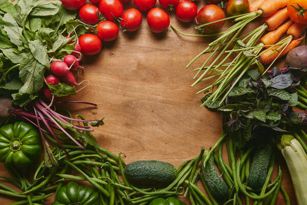 Frame of healthy green and red vegetables on wooden table