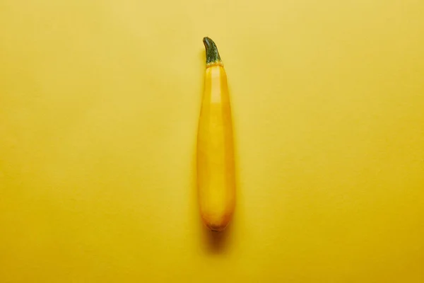 Single yellow squash on yellow background