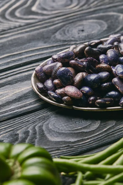 暗い木製のテーブルに紫インゲン豆とプレート  — 無料ストックフォト