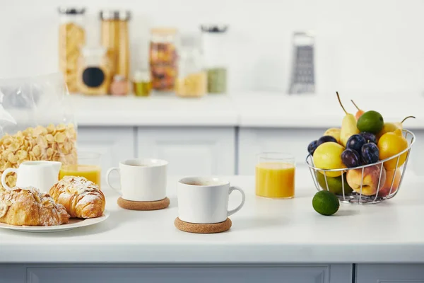 白い卓上キッチンでの朝食のコーヒーとクロワッサンのカップのビューを閉じる — ストック写真