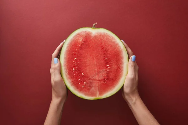 Imagen Recortada Mujer Sosteniendo Mitad Sandía Sobre Superficie Roja — Foto de Stock