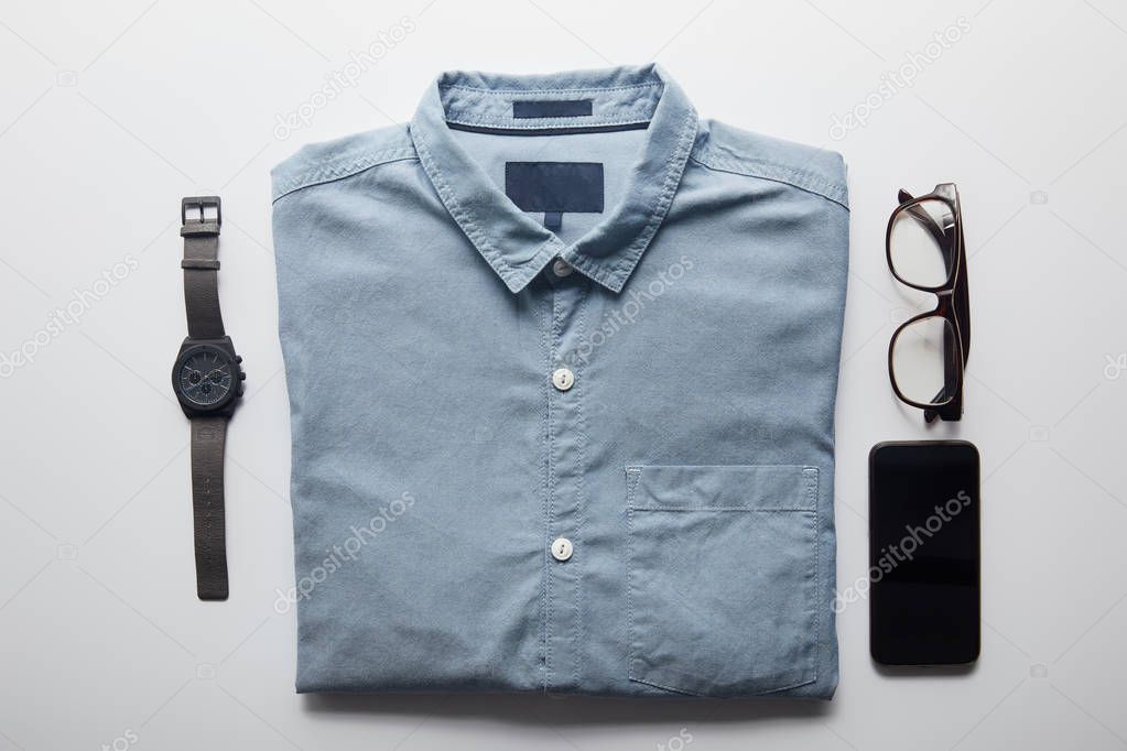 flat lay of shirt, smartphone and glasses isolated on white