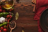 pohled shora červený ubrus kulatý talíř, koření a zeleniny na dřevěný povrch