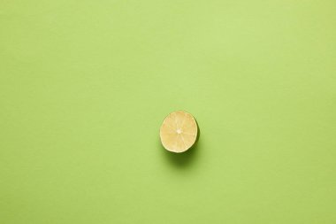 top view of halved ripe lime on light green background clipart