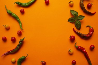 top view of fresh ripe tomatoes and chili peppers on orange background clipart