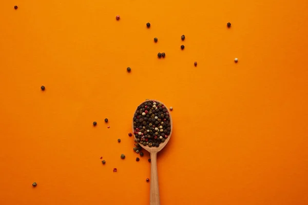 Top View Wooden Spoon Peppercorns Orange Background — Free Stock Photo