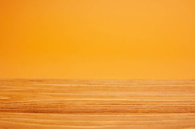 empty wooden surface and bright orange background clipart