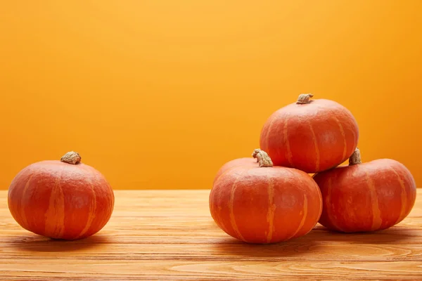 Verse Rijpe Pompoenen Houten Oppervlak Oranje Achtergrond — Stockfoto
