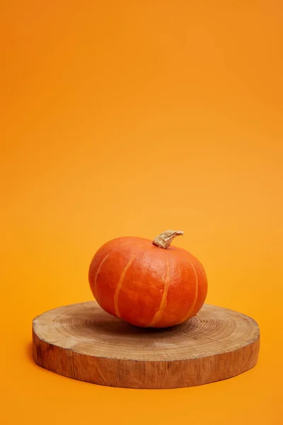 Calabaza Entera Madura Sobre Tabla Redonda Madera Sobre Fondo Naranja —  Fotos de Stock