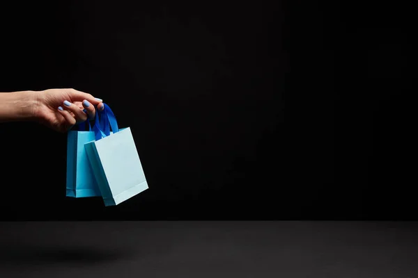 Visão Parcial Mulher Segurando Sacos Compras Papel Azul Fundo Preto — Fotografia de Stock