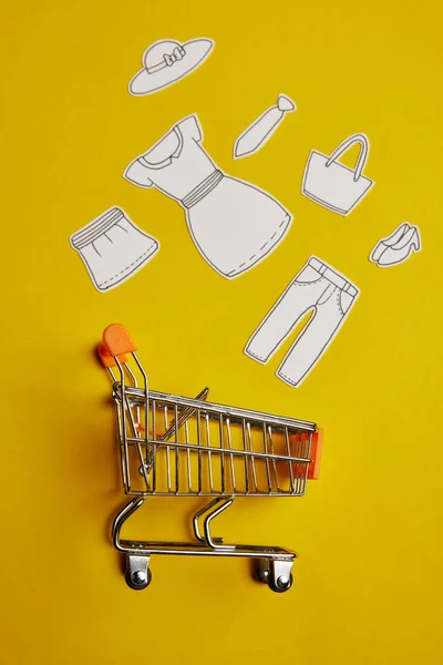 Bovenaanzicht Van Weinig Winkelwagentje Met Papier Kleren Gele Achtergrond — Stockfoto