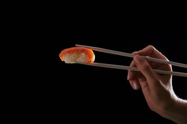 sıcak siyah izole somon nigiri suşi tutan kadının kırpılmış
