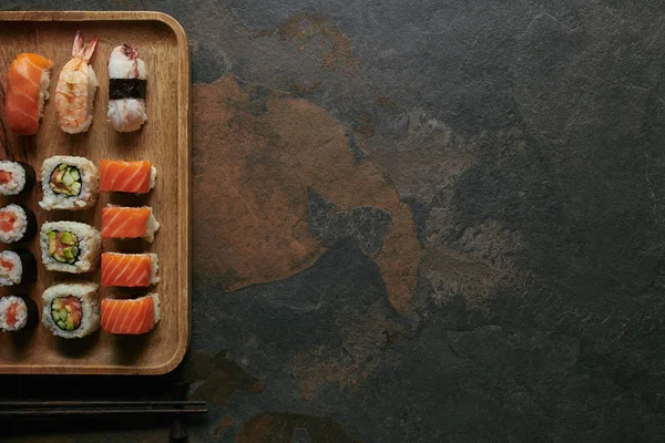 Top View Arranged Sushi Set Wooden Plate Chopsticks Dark Surface — Stock Photo, Image