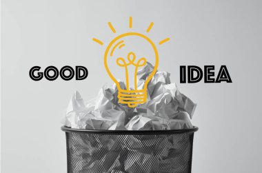 Office çöp kutusu beyaz ışık ampul ve iyi fikir yazı ile izole buruşuk kağıtlar ile