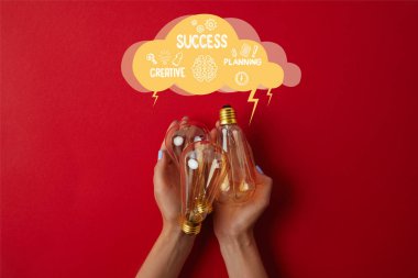 woman holding vintage incandescent lamps on red tabletop and cloud with business ideas - success, creative, planning clipart