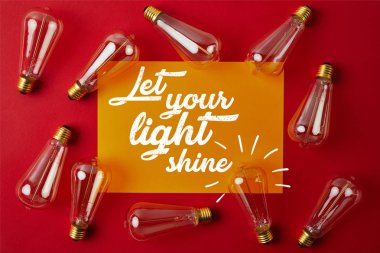 top view of vintage incandescent lamps on red surface with yellow paper and 