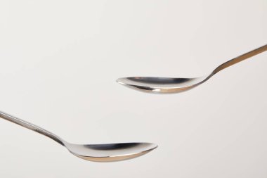 close up view of empty teaspoons on grey background clipart