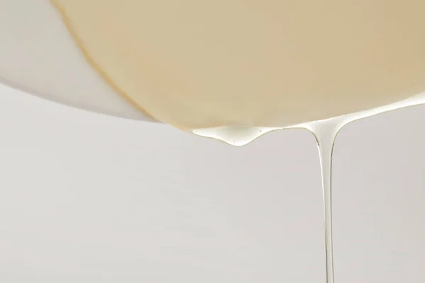 Κλείνω Πάνω Θέα Από Μέλι Που Ρέει Από Άσπρο Πιάτο — Δωρεάν Φωτογραφία
