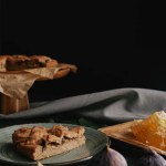 Vue rapprochée de tarte cuite au four, cire d'abeille et figues disposées sur une surface sombre