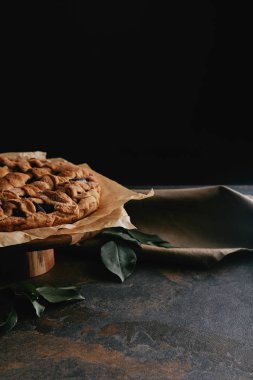 Ev yapımı pasta bakış grungy masa üstü siyah arka plan ile kürsüye pasta üzerinde kapatın