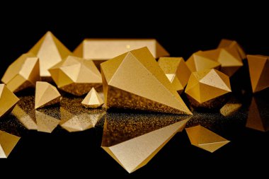 close-up view of shiny pieces of gold and golden dust reflected on black    clipart