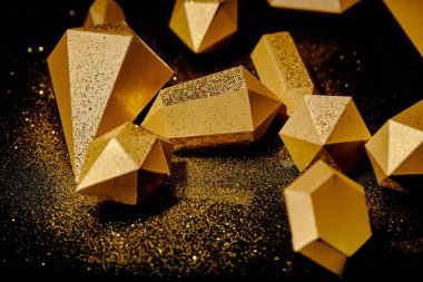 close-up view of shiny golden pieces and dust on black  clipart
