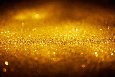 abstract shiny gold glitter on dark background clipart