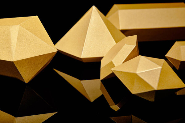 close-up view of shiny faceted golden pieces reflected on black 