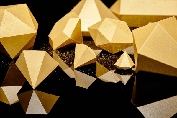 glittering faceted pieces of gold reflected on black background