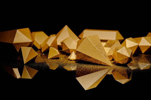 close-up view of shiny golden glittering pieces of gold reflected on black 