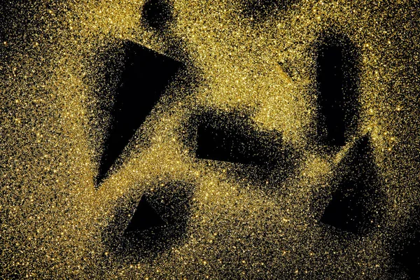 black shapes on golden glittering background