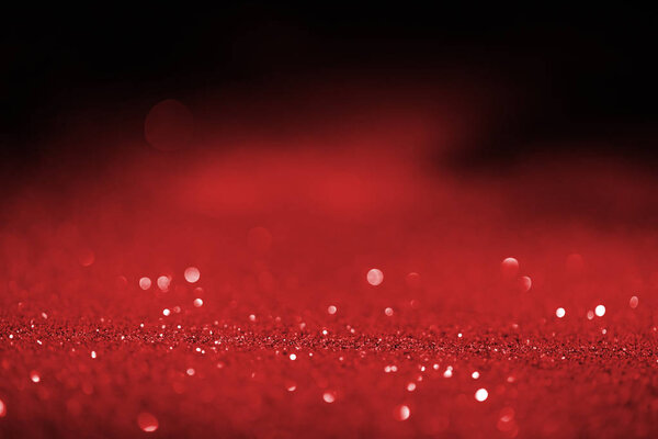 abstract blurred red glitter on dark background