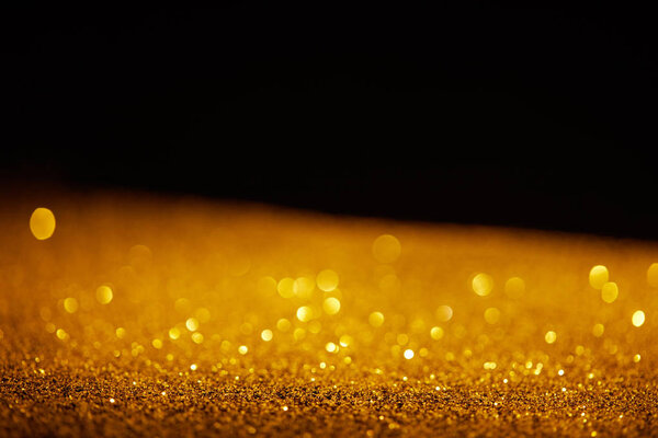размытый золотой блестящий блеск на черном фоне

