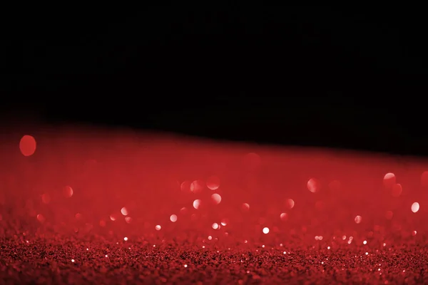 blurred red glowing glitter on black background