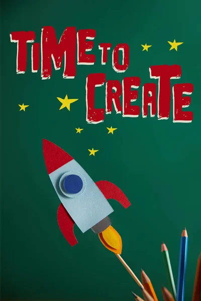 pencils and colorful rocket on green chalkboard with \