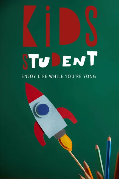 铅笔和五颜六色的火箭在绿色黑板与 孩子学生 享受生活 而你年轻 — 免费的图库照片
