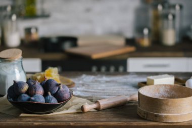 close-up shot of fig pie ingredients standing on rustic wooden table covered with flour clipart