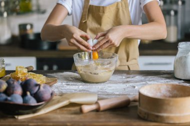 pasta hazırlık sırasında kaseye yumurta kırma kadın görüntüsünü kırpılmış