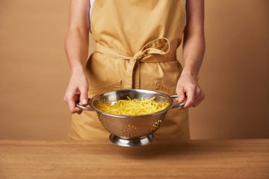 sarı önlük kevgir spagetti ile tutarak atış kadının kırpılmış