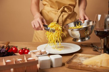 Spagetti tabağına kevgir koyarak önlük kadında doz kırpılmış