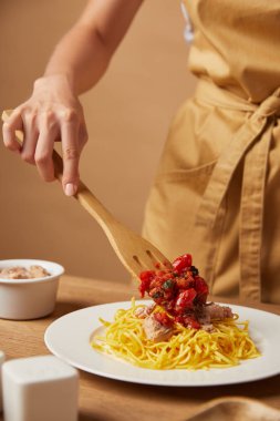 soslu makarna tahta spatula ile koyarak kadın görüntüsünü kırpılmış