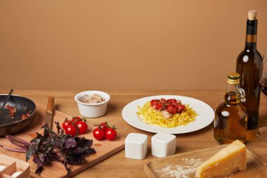tabak makarna çeşitli malzemeler ve ahşap masa etrafında şarap ile