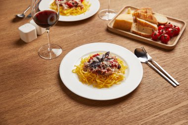 Romantik akşam yemeği için tabak spagetti kırmızı şarap gözlük ile yakın çekim vurdu