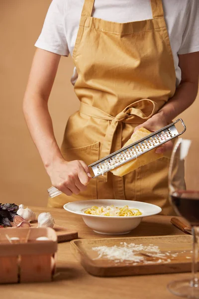 Cropped Shot Woman Grating Cheese While Cooking Pasta — Free Stock Photo