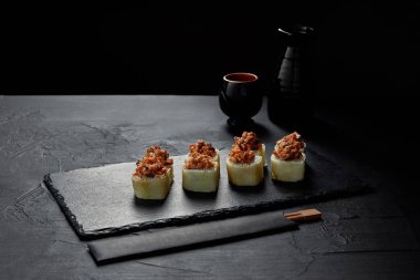 gurme suşi rulo kremsi yılan balığı ve kimchi mayonez ile kayrak kurulu ve kayrak gemide yemek çubukları