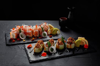close-up view of delicious fresh traditional sushi rolls on slate boards clipart